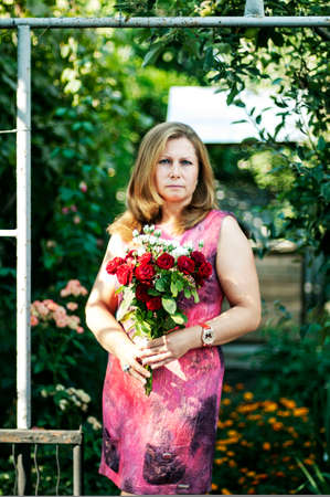 Young beautiful woman 40 years old posing . Portrait of a woman outdoorsの写真素材