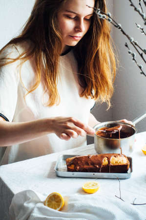 Cupcake for breakfast . Rustic  styling.  Homemade fresh-baked milk cake on the white tablecloth at a window. Country white kitchen.  The girl in the kitchen.Fresh hot coffee.の写真素材