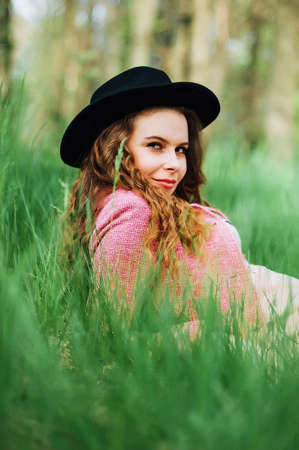 Portrait young elegant woman in pink coat and black hat. Fashion outdoors shot, street style...