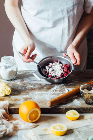 Steps of making cooking sandy cake with cherry filling : mixing ingredients: bowl, flour, eggs,  sour cream. See series. step on step recipe. Cooking course or kitchen mess. Women's handsの写真素材