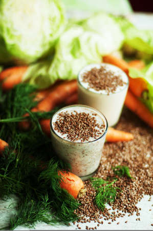 Glass of yogurt with crushed flax seeds  on a white background. Cocktail from kefir  in a transparent glass. Fresh homemade Kefir shake with flax seeds for a breakfast. Bio homemade dairy beverage.の写真素材