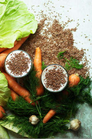 Glass of yogurt with crushed flax seeds  on a white background. Cocktail from kefir  in a transparent glass. Fresh homemade Kefir shake with flax seeds for a breakfast. Bio homemade dairy beverage.の写真素材