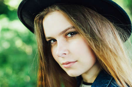 Stylish spring bohemian outfits. Beautiful young woman with long direct hair thin slender figure perfect body and pretty face natural make-up wearing a knitted whites weater  in blooming acacia gardenの写真素材