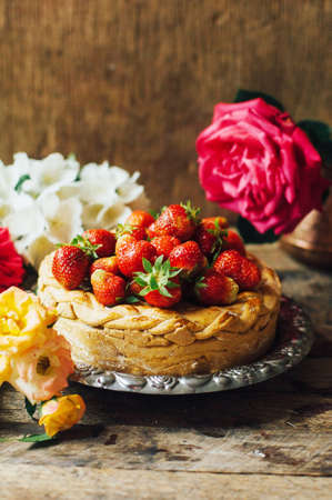 Homemade cherry and strawberry  pie on rustic background. Delicious Homemade Cherry Pie with a Flaky Crust. Rustic dark style. decorated with roses and jasmine flowers. Dessert for the familyの写真素材