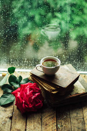 Romantic background with cup of tea, flowers and open book over wooden table. coffee cup book and white plumeria flower on table,の写真素材