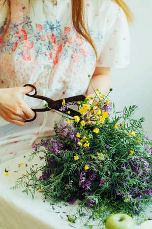 beautiful bouquet of purple and yellow wildflowers in the room light on a white table.の写真素材