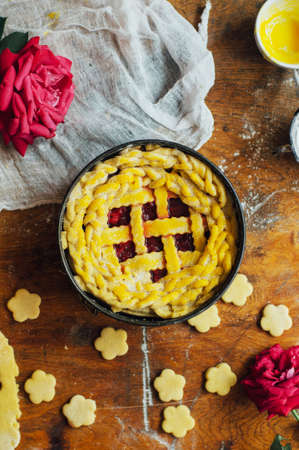 Ingredients for baking cake stuffed with fresh cherry pie. Female preparing cherry pie. Rustic dark style. See series recipe step on step. Womans hands. Recipe for homemade pie on short pastryの写真素材