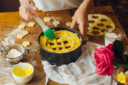 Ingredients for baking cake stuffed with fresh cherry pie. Female preparing cherry pie. Rustic dark style. See series recipe step on step. Womans hands. Recipe for homemade pie on short pastryの写真素材