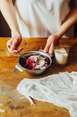 Ingredients for baking cake stuffed with fresh cherry pie. Female preparing cherry pie. Rustic dark style. See series recipe step on step. Womans hands. Recipe for homemade pie on short pastryの写真素材
