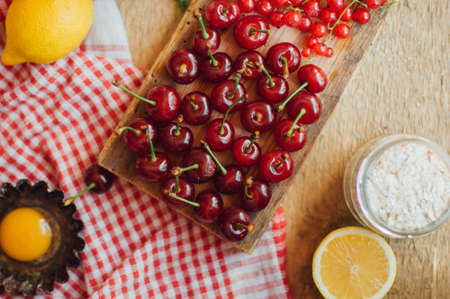 Fresh red cherries on a rustic  wooden table.  Ripe cherries i on wooden rustic background. Fresh cherries berries  on dark rustic wooden backgroundの写真素材