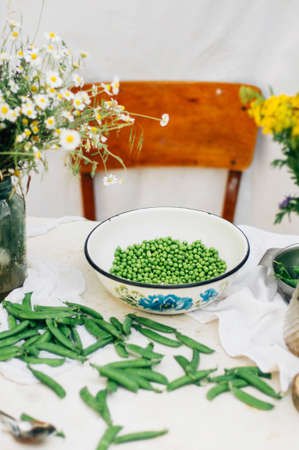 Woman podding fresh peas in the kitchen. Woman podding fresh peas in the kitchen. 
Fresh peas and pods. Large amount of fresh organic pea pods.の写真素材