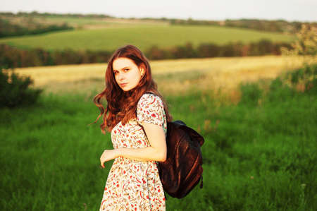 Woman with backpack in the nature. Young beautiful woman portrait .Girl with the wind in her hair. close portrait of young female woman girl .Analog shot of young woman with a backpackの写真素材