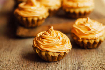 cupcakes on wooden table. Homemade decorated muffins on the table. sweet table full of homemade desserts.  muffins with rasberries frosting. Homemade muffins with wild rasberries and protein creamの写真素材