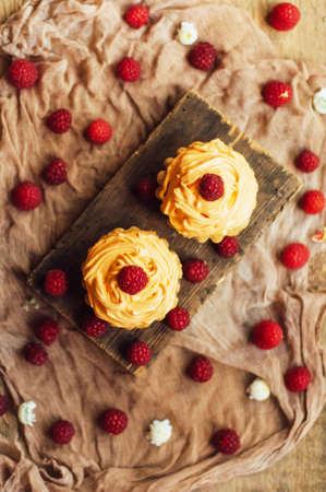 cupcakes on wooden table. Homemade decorated muffins on the table. sweet table full of homemade...