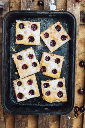 Homemade cherry cake ready to be eaten. Female hands making a cherry pie. Homemade Cherry pie.の写真素材