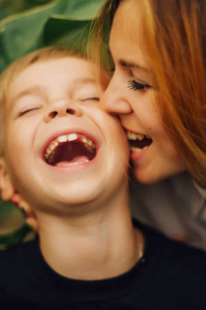 Portrait of a happy mother and her son  outdoor.  Series of a mother and son outdoor portrait in a park. Portrait of smiling mother and son. Family photo. The concept of a happy family.の写真素材