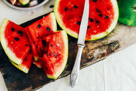 White cantaloupe and watermelon sliced on the table. Eating appetizer with family. Overhead view of melons on white background. Fresh Watermelon. remains of an eaten watermelonの写真素材