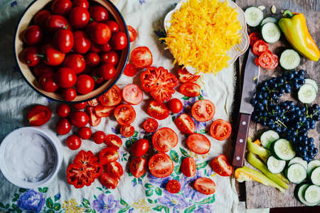 Tomato on wooden table. Freshly Picked red Tomatoes. Variation of tomatoes on wooden surface. Vegetables in the section. Harvesting. Healthy food from the garden.の写真素材