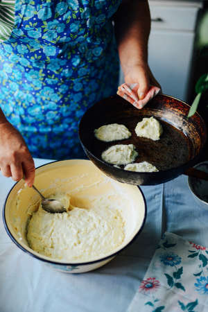 The woman is cooking pancakes. Spiced butternut squash ancakes.Spiced butternut squash pancakes with potatos and apple. Cooking pancakes for breakfastの写真素材