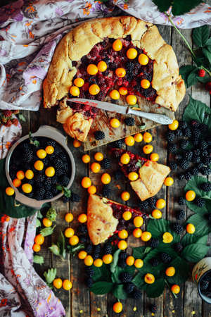 freshly baked berry pie. Blackberries pie with a slice missing. Berry pie preparation.   pie in summer with fresh picked blackberries.の写真素材