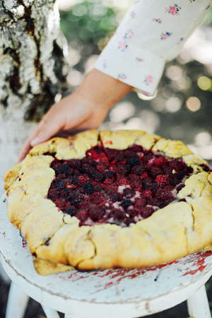 freshly baked berry pie. Blackberries pie with a slice missing. Berry pie preparation.   pie in summer with fresh picked blackberries.の写真素材
