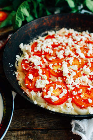 Veggie pizza. Pizza with tomatoes, shallot and fresh herbs. Cherry Tomato Wood Fired Pizza. Homemade margarita pizza sitting on a wooden cutting board. Pizza with pesto, mozzarella and cherry tomatoesの写真素材