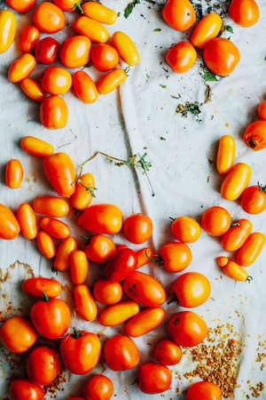 Tomato on wooden table. Freshly Picked red Tomatoes. Variation of tomatoes on wooden surface. Vegetables in the section. Harvesting. Healthy food from the garden.の写真素材
