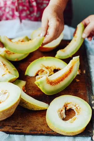 Melon on the table. Cantaloupe salad. Delicious fruits on dark background. slices of melon on a wooden tabletop.の写真素材