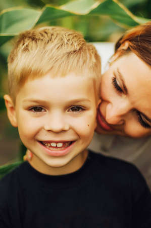 Portrait of a happy mother and her son  outdoor.  Series of a mother and son outdoor portrait in a park. Portrait of smiling mother and son. Family photo. The concept of a happy family.の写真素材