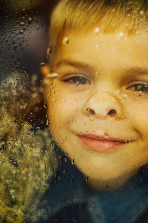 Child's happy face . Portrait of a Cute Kid.  little boy with short blond hair and brown yeas. Beautiful little boy seven years posing with a hat and denim shirt. Smailing boyの写真素材