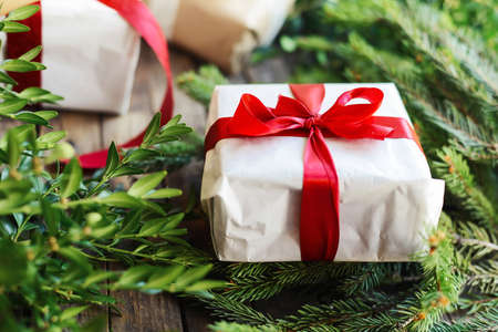 Extensive series of holiday shots with a variety of props and backgrounds. Lots of copyspace for ads. Christmas presents on wooden table. A couple of gifts wrapped in Christmas themed wrapping paper.の写真素材