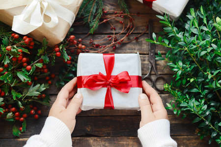 Extensive series of holiday shots with a variety of props and backgrounds. Lots of copyspace for ads. Christmas presents on wooden table. A couple of gifts wrapped in Christmas themed wrapping paper.の写真素材