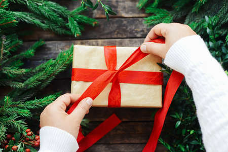 Extensive series of holiday shots with a variety of props and backgrounds. Lots of copyspace for ads. Christmas presents on wooden table. A couple of gifts wrapped in Christmas themed wrapping paper.の写真素材