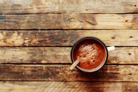 Woman holding cup of hot chocolate. Hot Chocolate in wooden table.  Woman having a cup of coffe....