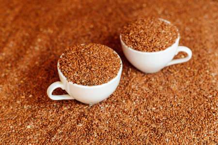 buckwheat seeds on a rustic wooden table. Flax seed in wood bowl. Flaxseeds in bowl.