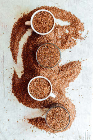 buckwheat seeds on a rustic wooden table. Flax seed in wood bowl. Flaxseeds in bowl.の写真素材