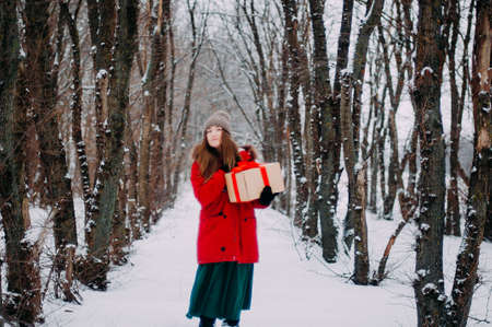 Young attractive girl embracing the snow in winter. Winter portrait of young womanの写真素材