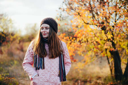Closeup outdoors portrait of gorgeous young  Caucasian woman.  outdoors in park on sunny fall day. colorful autumn portrait. Portrait of a beautiful, dreamy  girl with long  hair. in autumn parkの写真素材