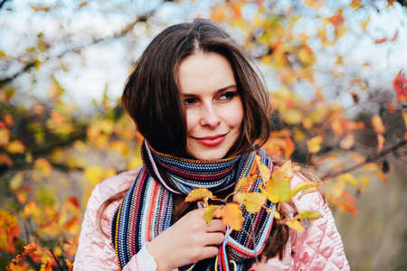 Closeup outdoors portrait of gorgeous young  Caucasian woman.  outdoors in park on sunny fall day. colorful autumn portrait. Portrait of a beautiful, dreamy  girl with long  hair. in autumn parkの写真素材