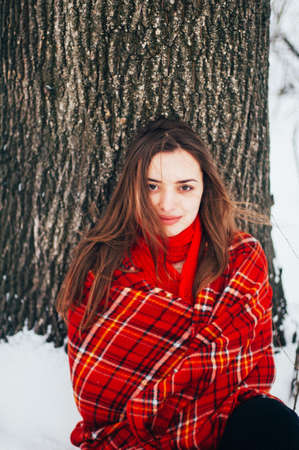 Female portrait outdoors serious expression. Young woman outside wearing warm winter clothing. ...