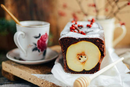 Rustic open apple and pear pie in rustic table setting. Baked pears wrapped in  pastry. Fall colours. A delicious chocolate cake with pear filling berries decorationの写真素材