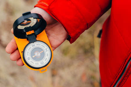 Woman traveler sitting on autumn nature background, point of view shot. Unrecognizable young girl on a hike in autumn forest with a compass in hand. Relax in a nature. Traveler resting in the natureの写真素材