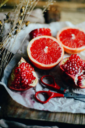 Fresh red pomegranate and grapefruit On a wooden background. Pomegranate in  plate on  wood background.  Pomegranate  on wood textured background. Overhead view image.の写真素材