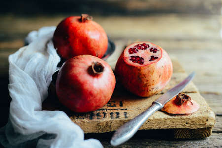 Fresh red pomegranate and grapefruit On a wooden background. Pomegranate in  plate on  wood...
