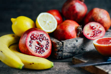 Fresh fruits. Mixed fruits background. Healthy eating, dieting. Background of healthy fresh fruits.  Fruit salad - diet, healthy breakfast. pomegranate, persimmon, tangerine, banana, lemonの写真素材