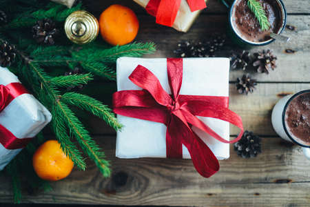 Extensive series of holiday shots with a variety of props and backgrounds. Lots of copyspace for ads. Christmas presents on wooden table. A couple of gifts wrapped in Christmas themed wrapping paper.の写真素材