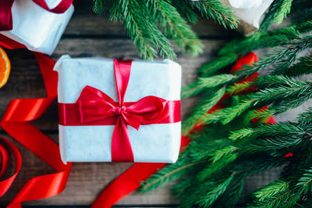 Extensive series of holiday shots with a variety of props and backgrounds. Lots of copyspace for ads. Christmas presents on wooden table. A couple of gifts wrapped in Christmas themed wrapping paper.の写真素材