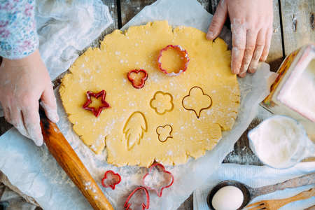 Homemade bakery making, gingerbread cookies close-up.  xmas sweet, winter holidays. Hands roll out gingerbread dough on board. Cookies or pie preparing. Baking ingredients. Christmas New Year conceptの写真素材