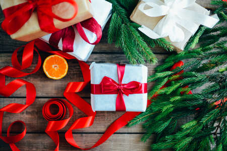 Extensive series of holiday shots with a variety of props and backgrounds. Lots of copyspace for ads. Christmas presents on wooden table. A couple of gifts wrapped in Christmas themed wrapping paper.の写真素材