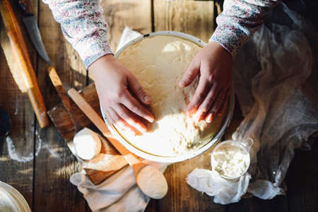 Close up view of baker kneading dough. Homemade bread. Hands preparing bread dough on wooden table. Preparing traditional homemade bread. Woman hands kneading fresh dough for making breadの写真素材